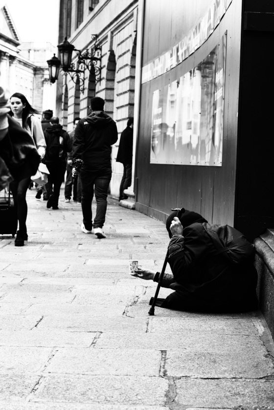 A homeless woman begs on the street in Dublin Ireland