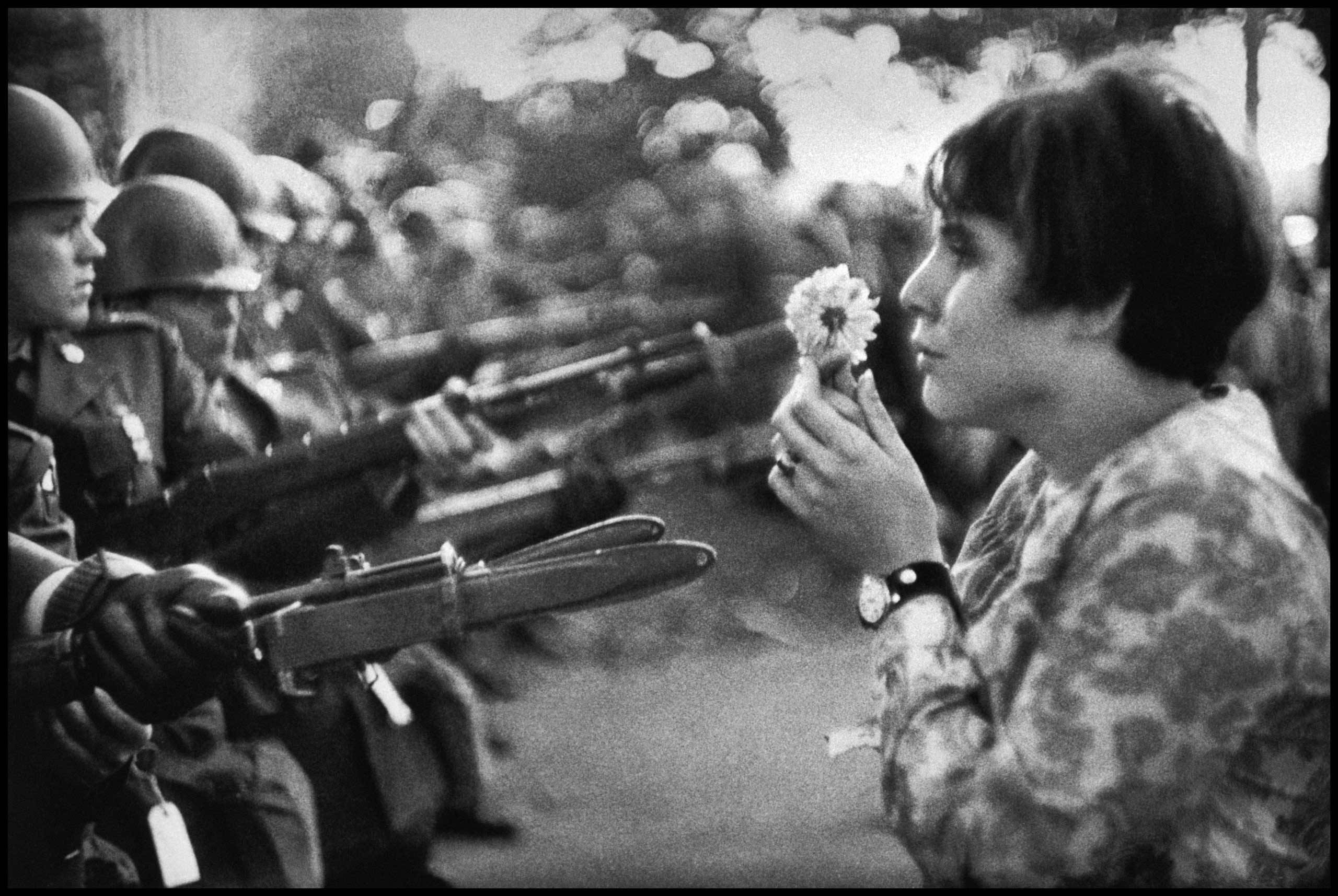 Jan Rose Kasmir offers a flower to a solider at Anti War protest in Washington DC